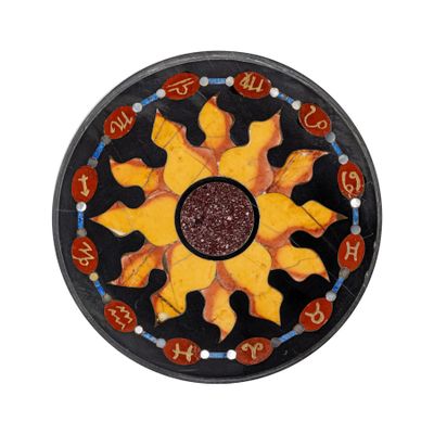 une assiette noire ornée d'un motif représentant un soleil