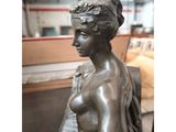 bronze statue of a woman sitting on a bench in a room