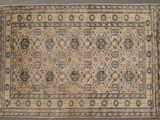 un tapis persan ancien, orné d'un motif beige et bleu sur fond gris