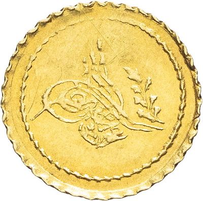 Gros plan sur une pièce d'or portant une écriture arabe