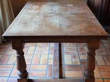 a wooden table that is sitting on a tiled floor