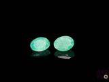 a pair of green glow earrings on a black background