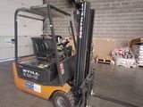 a fork lift truck parked in a warehouse with pallets