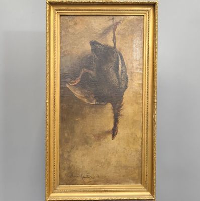 un tableau représentant un canard, accroché au mur dans un cadre doré