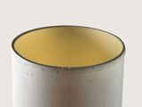a white cup with a yellow rim sitting on a table