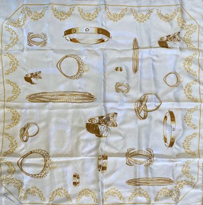 une image représentant une écharpe blanche ornée de bijoux dorés