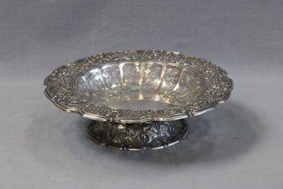 a silver bowl on a silver stand on a table