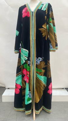 a black and green dress with pink flowers on a mannequin
