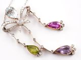 three different colored stones and silver jewelry on a white surface