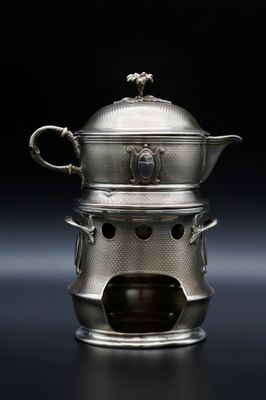 une théière ancienne en argent, avec son couvercle et ses anses, sur fond noir