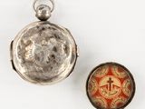 silver pocket watch with a red and white enamel picture on the front