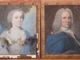 Deux tableaux représentant un homme et une femme sont présentés dans un cadre doré.