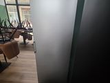 un réfrigérateur dans une pièce où il y a beaucoup de chaises