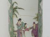 a vase with a painting on it sitting on a table