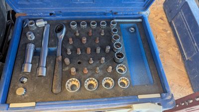 une boîte à outils bleue avec des outils sur une table