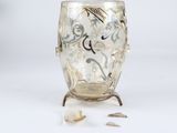 a glass vase with a silver design on it