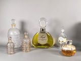 Plusieurs flacons de parfum sont alignés sur une surface blanche