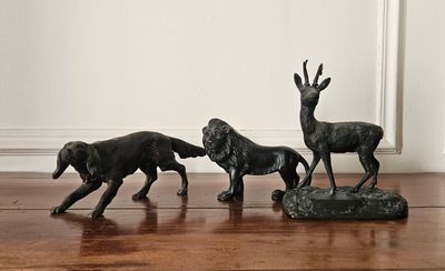 trois figurines représentant un chien et un cerf, posées par terre