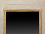 un miroir accroché au mur, avec un cadre doré