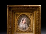 une vieille photo d'une femme en robe blanche dans un cadre doré