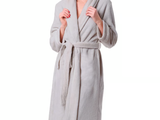 a woman in a robe standing with her hand in her pocket