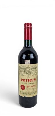 a bottle of red wine sitting on a white surface