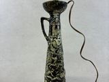 un vase noir et blanc surmonté d'une lumière