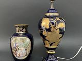 une paire de vases bleus et dorés posés sur une table à côté d'une lampe