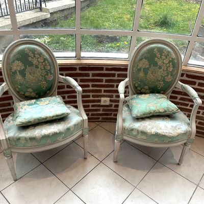pair of green and white chairs sitting in front of a window