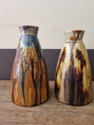 two vases that are sitting on a wooden table