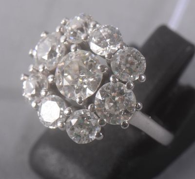 an image of a diamond cluster ring on a black stand