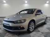 La voiture argentée est garée sur le sol à damier du showroom.