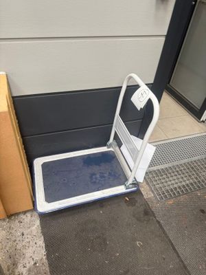 une plate-forme métallique recouverte d'un tapis bleu sur le trottoir