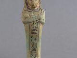 une statue égyptienne représentant un homme tenant un fruit et une poire