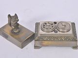 a small silver box with a figurine on top of it