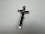 a close up of a metal cross on a white surface