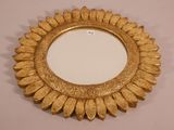 a close up of a gold mirror on a white surface