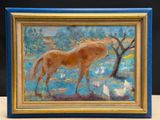 a painting of a horse in a blue frame on a table