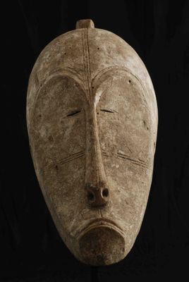 gros plan d'un masque en bois sur fond noir