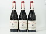 trois bouteilles de vin rouge sont alignées sur une surface blanche