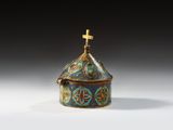 a small metal box with a cross on top of it