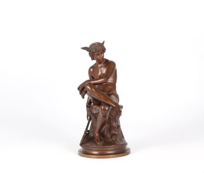 a bronze statue of a man sitting on a rock