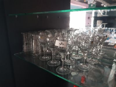 de nombreux verres à vin posés sur une étagère en verre dans un magasin