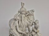 une statue représentant une femme et deux enfants assis sur un banc