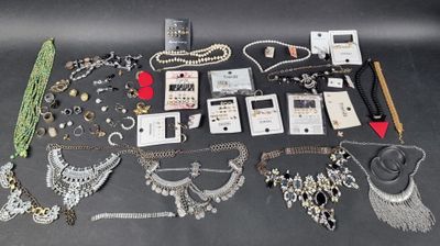 beaucoup de bijoux posés sur une table, à côté d'un téléphone portable