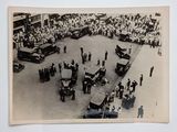 a black and white photo of a crowd of people watching a parade