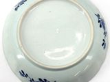 a white plate with blue flowers on it on a white surface