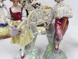 three figurines of people that are standing on a table
