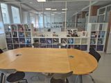 tables and chairs in a room with a lot of books on the shelves