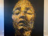 une image représentant un tableau représentant le visage d'un homme sur fond noir